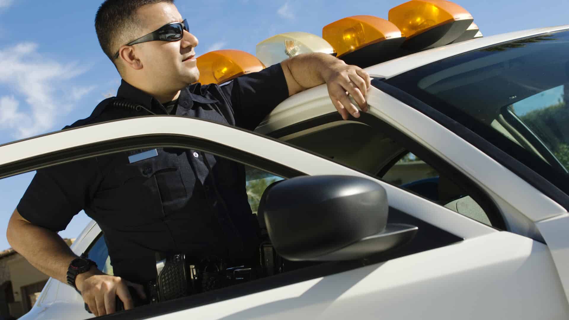 police-officer-leaning-on-patrol-car